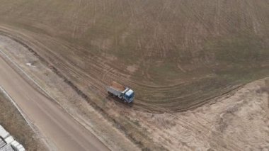 Toprak yolda giden boş bir çöp kamyonunun hava görüntüsü. İnşaat işi ve inşaat atığının imhası kavramı