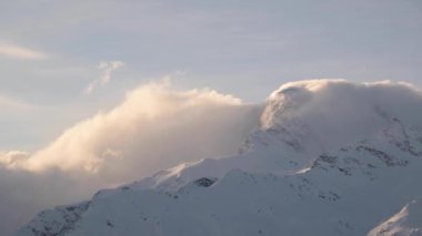 Zaman bulutları dağlarda akar. Akşamları yüksek karlı dağların üzerinden akar..