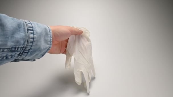 Die Hand mit Armbanduhr und Jeanshemd demnotiert die medizinischen weißen Handschuhe, die die Anforderungen an das Tragen von Handschuhen zur Vorbeugung und Sicherheit gegen Viren und Pandemien erläutern. — Stockvideo