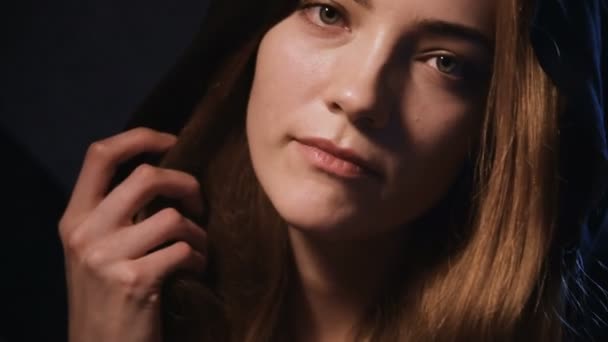 Un grand portrait d'une jolie fille blonde dans un capot flirte et flirte à la caméra séduisant et évoquant. Vacances discrètes Halloween et mascarade. Femme sédateur