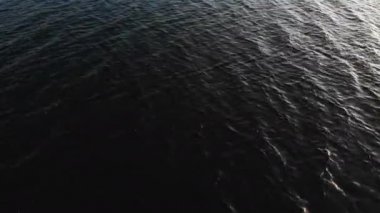 Donanma video geçmişi. Suyun karanlık yüzeyindeki hava görüntüsü küçük dalgalar halinde gider. Alçak tuş
