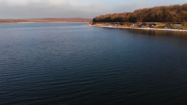 Vue aérienne depuis un drone volant à basse altitude sur la surface lisse du drone le soir après le coucher du soleil. Vidéo de fond avec plan d'eau naturel local