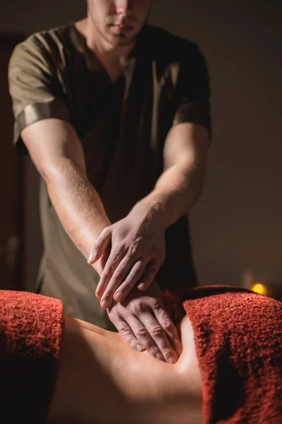 Massagem profissional das costas e parte inferior das costas. Massagem de massagista masculino um cliente para uma mulher em um quarto escuro à luz de velas — Fotografia de Stock
