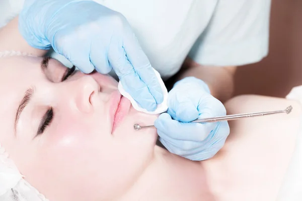 Cosmetology and facials. Mechanical removal of the cleaning of an adult womans face in the cosmetics office is a special tool. The concept of timely facial care — Stock Photo, Image