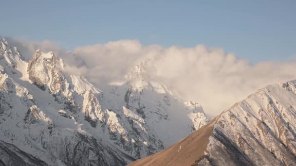 Las nubes del Timelapse fluyen en las montañas que fluyen sobre los picos en las altas montañas nevadas de la tarde . — Vídeo de stock