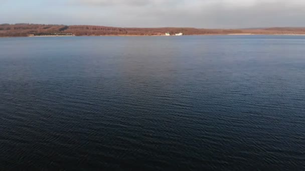 Vue aérienne depuis un drone volant à basse altitude sur la surface lisse du drone le soir après le coucher du soleil. Vidéo de fond avec plan d'eau naturel local