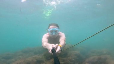 Fizik sporu yapan beyaz bir adam tarafından su altında çekilmiş bir selfie su altında çok güzel yüzer. Deniz kıyısında ya da okyanusta serbest dalış ve dinlenme kavramı.