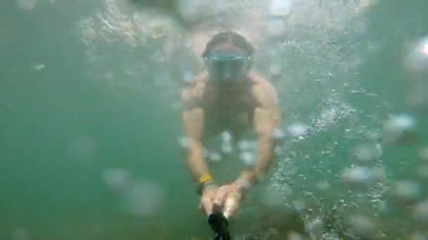 Uma selfie disparada debaixo de água por um homem caucasiano que ostenta um físico flutua lindamente debaixo de água. O conceito de mergulho livre e recreação na costa do mar ou no oceano — Vídeo de Stock