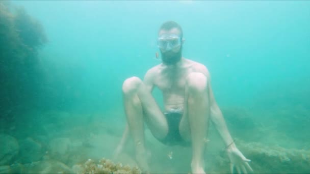 Lentamente muovendo un giovane barbuto cerca di meditare in una posa di loto in fondo al mare in acqua. Il concetto di meditazione zen e yoga subacqueo — Video Stock