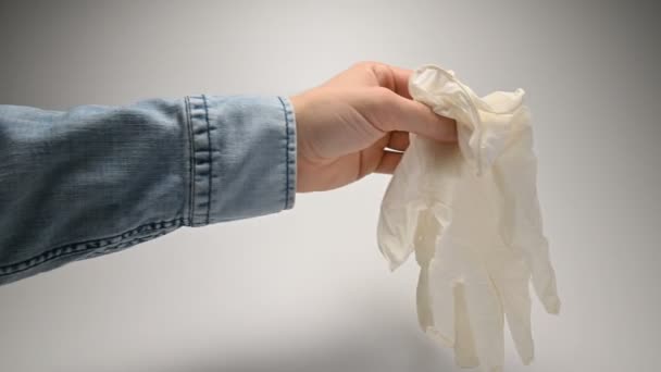 La main avec une montre-bracelet et une chemise en denim démolit les gants blancs médicaux expliquant les exigences de porter des gants pour la prévention et la sécurité avec une protection contre les virus et les pandémies — Video