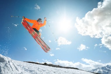 Güneşli bir ilkbahar ya da kış gününde mavi gökyüzüne ve güneşe karşı bir vurucuyla ozdou kayakçısında bir numarayla zıpla