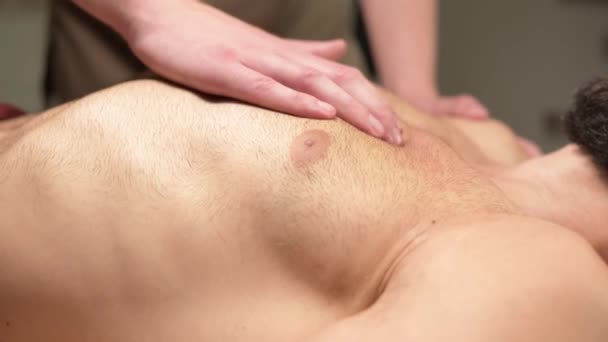 职业治疗师在职业按摩院为男性按摩运动员的胸肌。玛瑙疗法专家专业帮助的概念 — 图库视频影像
