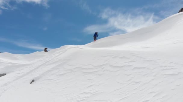 Flygfoto idrottsman skidåkare freerider står ovanpå åskådarplats högt i bergen förbereder sig för att stiga ner. Skitour och freerid i norra Kaukasus oförberedda sluttningar — Stockvideo
