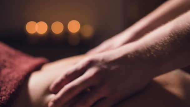 Close-up Cosmetologie en fysiotherapie. Professionele massage op de onderrug van een vrouw wordt gemaakt door een masseur man. Concept van manul therapie en massage spa behandelingen — Stockvideo