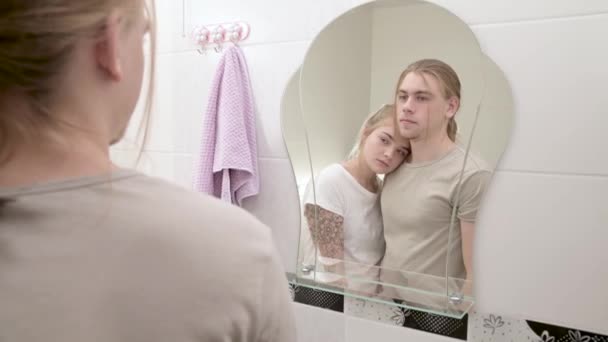 Un jeune couple séduisant et une femme aux cheveux longs se mettent en ordre le matin dans la salle de bain. La notion de jeune famille et de mariage civil — Video