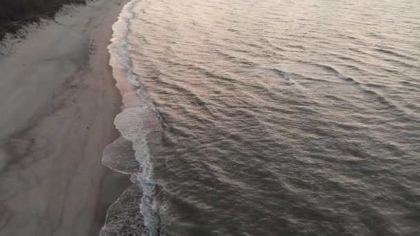 Αεροφωτογραφία της πτήσης πάνω από την ακτογραμμή της Βαλτικής Θάλασσας το βράδυ αμέσως μετά το ηλιοβασίλεμα. Έννοια ενός βίντεο του υποβάθρου της θάλασσας από τη σκοπιά των πουλιών — Αρχείο Βίντεο