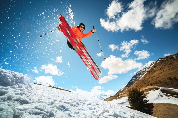 Hoppa med ett trick i ozdou idrottare skidåkare med en kicker på en solig dag på våren eller vintern mot den blå himlen och solen — Stockfoto