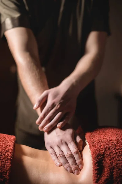 Cosmetologia e fisioterapia. A massagem profissional na parte inferior das costas de uma mulher é feita por um massagista. Conceito de terapia de manul e tratamentos de spa de massagem — Fotografia de Stock