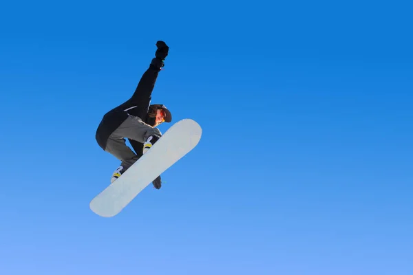 Snowboarder Mädchen macht einen Trick beim Springen mit einem Griff gegen den blauen Himmel. Blauer Gradienten Hintergrund isoliert Sportler im Flug — Stockfoto