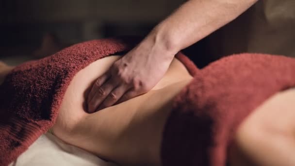 Zbliżenie Kosmetologia i fizjoterapia. Profesjonalny masaż dolnej części pleców kobiety wykonywany jest przez masażystę. Koncepcja terapii manualnej i masażu zabiegów spa — Wideo stockowe