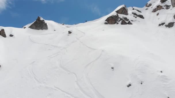 Flygfoto idrottsman skidåkare freerider står ovanpå åskådarplats högt i bergen förbereder sig för att stiga ner. Skitour och freerid i norra Kaukasus oförberedda sluttningar — Stockvideo