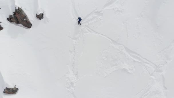 Vista aérea atleta esquiador freerider se encuentra en lo alto de las montañas preparándose para descender. Skitour y freeride en las laderas no preparadas del Cáucaso Norte — Vídeos de Stock