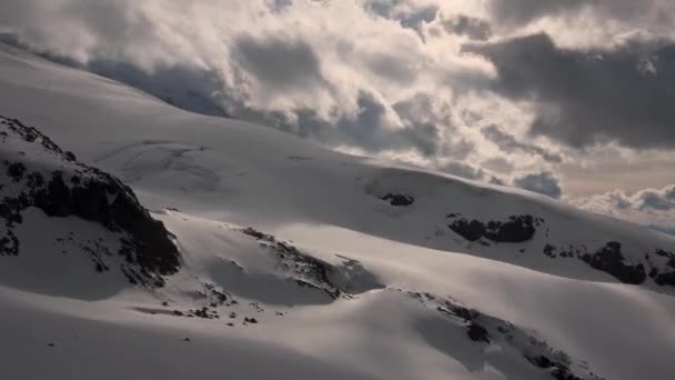 La pendiente del timelapse es el movimiento meridional del abeto de nubes con el viento y la nieve antes de la puesta del sol. Timelapse de gran altitud con nieve. Cambiando el clima en las montañas — Vídeos de Stock