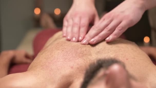 Erkek masör, profesyonel masaj salonundaki sporcu sporcuya göğüs kası masajı yapıyor. Göğüs kası ve göğüs kası sağlığı kavramı. — Stok video