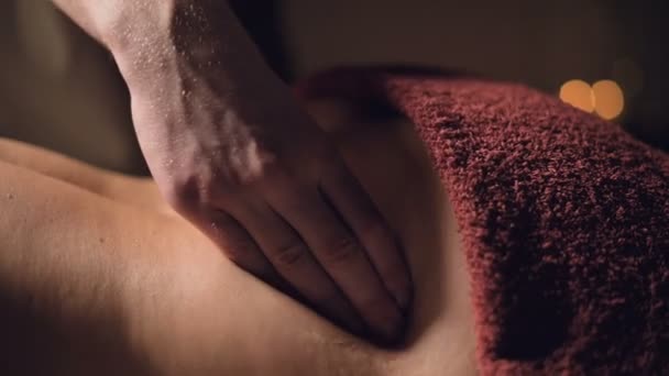 Close-up Kosmetologie a fyzioterapie. Profesionální masáž do dolní části zad ženy provádí masér. Koncepce manuální terapie a masážní lázeňské léčby — Stock video