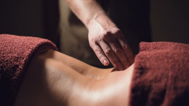 Närbild Kosmetologi och sjukgymnastik. Professionell massage till nedre delen av ryggen på en kvinna görs av en massör man. Begreppet manuell terapi och massage spabehandlingar — Stockvideo