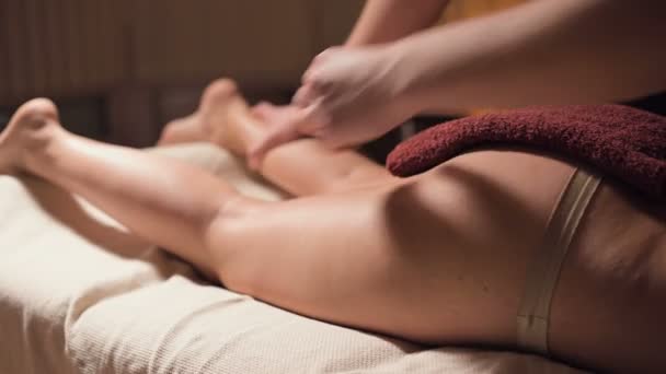 Massagem de quadril profissional close-up no salão de spa com uma luz quente agradável. Um massagista masculino faz uma massagem premium a uma cliente feminina. Luta contra a celulite e o corpo profissional e cuidados com a pele — Vídeo de Stock