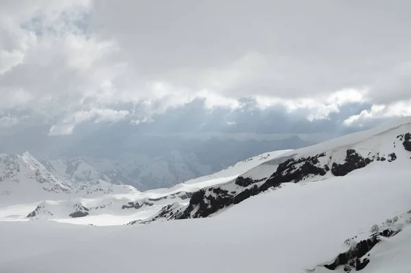 Paisagens altas de montanha à noite montanhas íngremes rochosas cobertas de neve da principal cadeia montanhosa do norte do Cáucaso — Fotografia de Stock