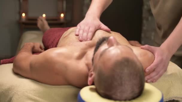 Massagem esportiva do músculo peitoral de um homem atleta após o treinamento, relaxamento e revitalização dos músculos do peito e do peito — Vídeo de Stock