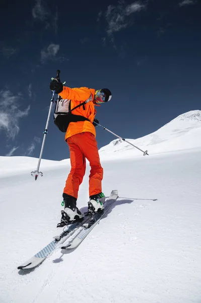 Wspinaczka narciarza z plecakiem w masce i okularami przeciwsłonecznymi na nartach z kijkami na wspinaczkę po freeride i backcountry. Północny Kaukaz. Wspinaczka na wulkan Elbrus — Zdjęcie stockowe