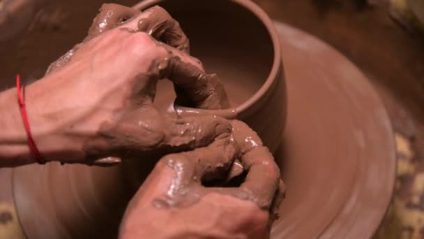 A close-up of a potters hand creates a clay bowl on a potters wheel. Handmade clay tea accessories — Stock Video