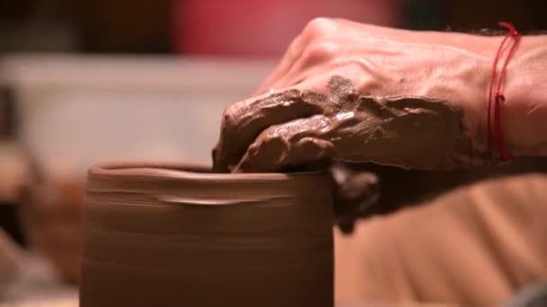 陶工手的特写在陶工轮上创造了一个陶土碗。手工制作的粘土茶具 — 图库视频影像
