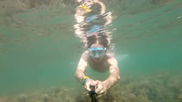 Egy víz alatti szelfi, amit egy kaukázusi férfi lelőtt, és fizikummal rendelkezik, gyönyörűen lebeg a víz alatt. A szabad búvárkodás és rekreáció koncepciója a tengerparton vagy az óceánon — Stock videók