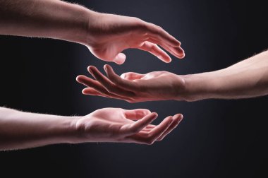 Endişeli bir adamın iki eli başka bir adamın eline dokunmak ister. lgbt topluluklarında önemseme kavramı