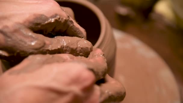Een close-up van een pottenbakkershand creëert een kleikom op een pottenbakkerswiel. Handgemaakte klei thee accessoires — Stockvideo