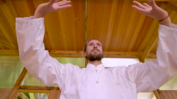 Close-up Gebaarde blanke man met witte kleren om concentratie en ademhaling te oefenen voordat hij Qigong tai chi beoefent — Stockvideo