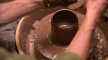 Erkek ellerinin çömlekçi çarkında kil kase yaptığı yakın plan. El işi ve kilden yapılmış özel çay takımları.