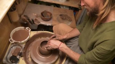 Erkek eller çömlekçi çarkında kil kase yapıyor. El işi ve kilden yapılmış özel çay takımları.