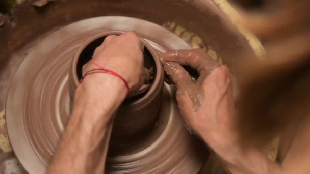 Primer plano de manos masculinas haciendo un tazón de barro en un volante de alfarero. Artesanía y producción de vajilla de té exclusiva de arcilla — Vídeos de Stock