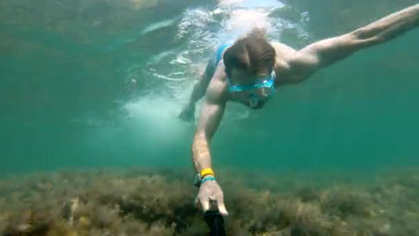Под водой красиво плавает селфи, сделанное кавказцем, носящим телосложение. Понятие свободного дайвинга и отдыха на морском побережье или на океане — стоковое видео