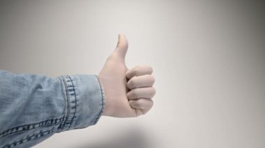 Beyaz arka plandaki beyaz tıbbi eldiven parmak hareketlerini gösteriyor.