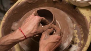 Erkek ellerinin çömlekçi çarkında kil kase yaptığı yakın plan. El işi ve kilden yapılmış özel çay takımları.