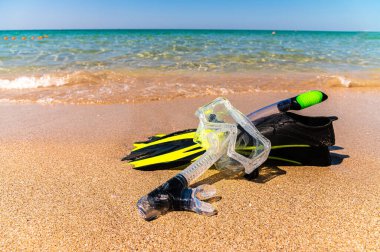 Şnorkelle yüzme çantası. Yüzgeçler, şnorkel ve şnorkel denizin ya da okyanusun altın plajında. Sahilde tatil ve dinlenme konsepti