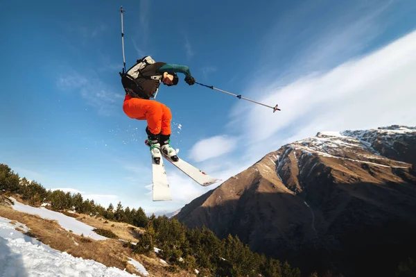 Profisportler Junge männliche Skifahrer mit Rucksack und Skimaske macht einen Trick im Flug nach einem Sprung aus einem Kicker — Stockfoto