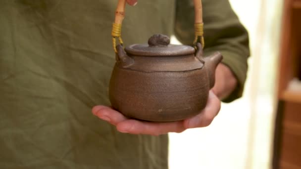 Pembuat tembikar jantan menunjukkan karyanya, Yixing, teko tanah liat untuk upacara teh buatan tangan di dekatnya. Kedalaman field yang dangkal — Stok Video