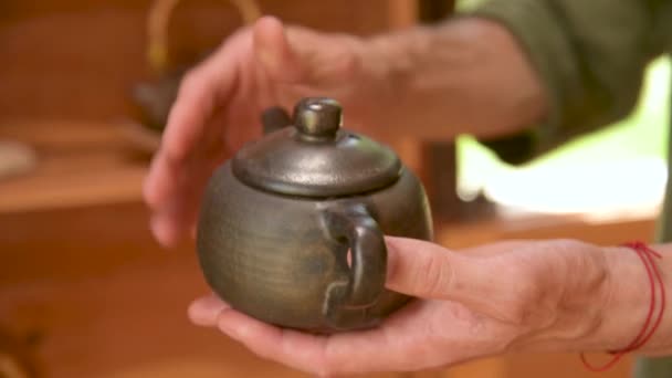 Een mannelijke pottenbakker toont zijn werk Yixing klei theepot voor een handgemaakte theeceremonie in de buurt. Ondiepe scherptediepte — Stockvideo